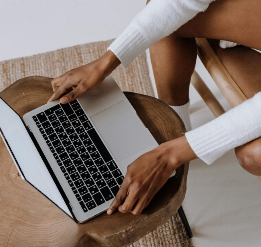 Close-up of a woman typing on a laptop indoors, focusing on technology and modern lifestyle.